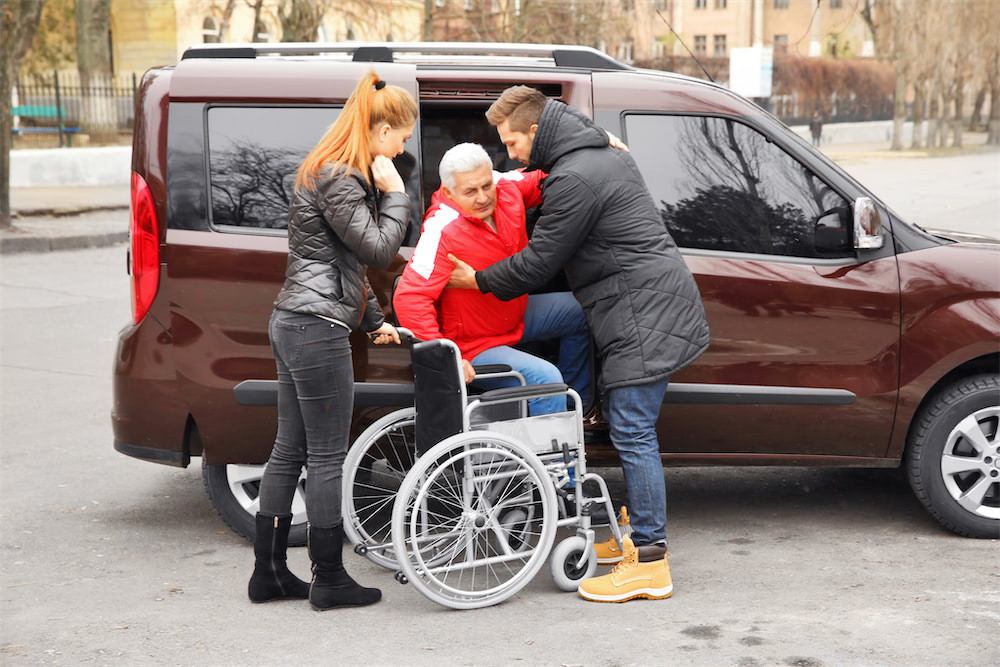 elderly man being helped into wheelchair